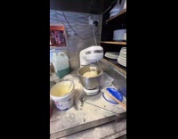 Woman using broken mixer for pizza dough