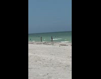 Woman black onesie do rapid poses beach