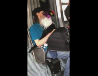 Guy holds big pokemon black plush toy with tall ears on subway train