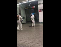 Two guys white hazmat suit subway station 