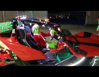 Grinch wearing santa suit drives red ATV