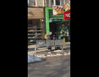 Guy on sidewalk bangs on black drum 