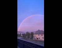 Double rainbow arc in sky at sundown