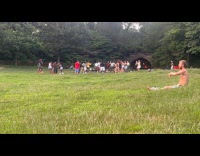 Man meditate at park while crowd dances