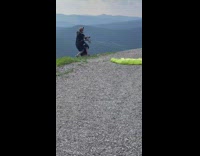Guy rides paraglide off mountain 