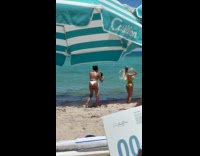 Woman green bikini films at the beach