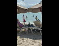 Man in white shirt rap video shoot at the beach