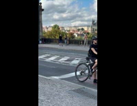 Collab IITW - Woman checkered top dances on the sidewalk biker on the side