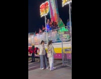 Two women dances near the amusement ride