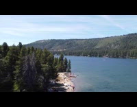 Drone flies over blue lake water people 