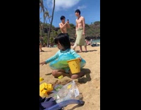 Man with green towel wrapped around at the beach