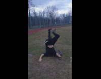 A guy with shoes on his hands backflip on neck