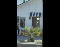 Man shirtless with tattoo poses and leans on the doorway