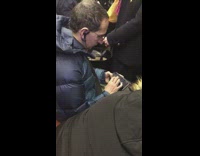 Collab Subway Creatures - Man in blue jacket playing trumpet on phone sitting in crowded subway