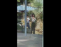 Man in vintage polo and sunglasses poses near the stairs