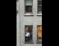 Man cleans window from high floor 