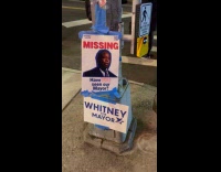 Woman shows missing mayor poster at street