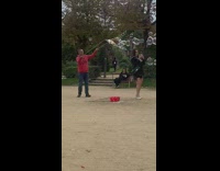 Woman in black dress pops bubbles at the park