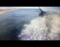 surfer in black wetsuit falls off surfboard and into water 