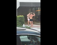 Man and Woman flexes muscles at the sidewalk