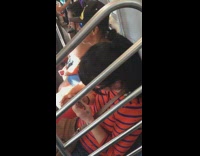 Woman orange blue striped shirt clips nails on train