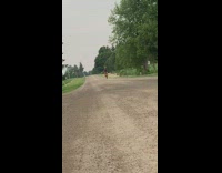 Guy in red does wheelie on motorcycle