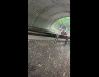 Car pass by sidewalk under tunnel rain