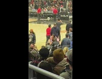 Woman with pink jacket poses in the basketball court