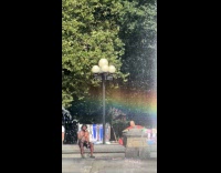 Shirtless man talking to himself at fountain