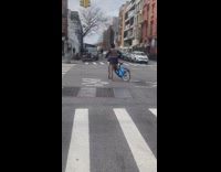 Man ride bike balance TV on head