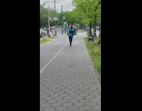 Woman in vest dances on sidewalk