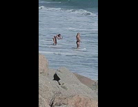 Woman in bikini top poses on the beach waves
