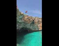 Red shorts guy backflips clear blue water 