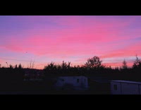 Guy stands outside and watches the sunset