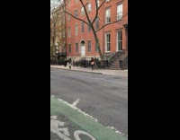 Guy holding rat costume mask walks sidewalk 
