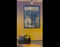 Guy in white costume seen through window 
