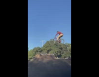 Guy rides bicycle over dirt hill falls 