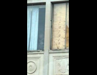 Old man standing window building