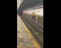 Construction workers work on train tracks to music 