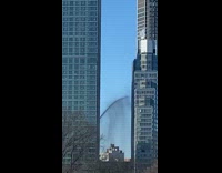 Dark water sprays out from the building