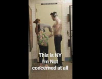 Woman helps guy wrap himself in saran plastic cling wrap black headphones in subway station