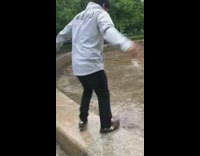 Guy jumps onto wet slippery tile floor , slips backwards and smacks the back of his head on the ground