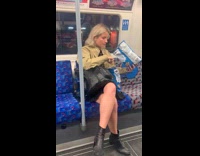 Woman licks seasoning off chip and puts in back in blue bag on subway train