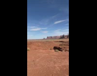 Woman in red dress spread arms in the desert