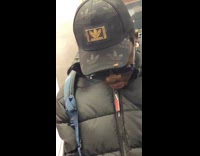 Cockroach crawls on man cap riding subway
