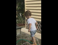 Little boy tries to drink sprinkler water trips on green house