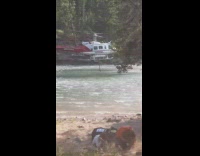 Helicopter Grabs Water from River near Kids