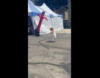 Girl dance with inflatable tube man blower