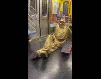 Gold mime man balancing skateboard on finger 