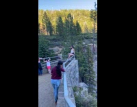 White shirt girl sits railing waterfall guy